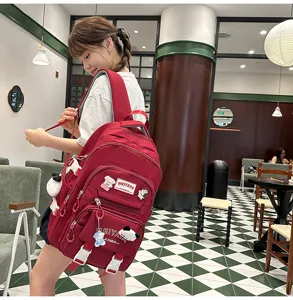 Detailed lifestyle shot of a large red backpack with cute pendants, ideal for students.