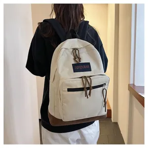 Casual canvas backpack with brown bottom, ideal for student travel and daily school use.
