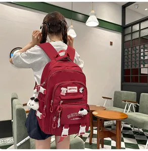 Large capacity red school backpack for students, featuring cute plush pendant and pockets.