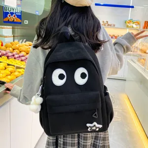 Cute black corduroy backpack with big eyes design, stylish casual school bag for women.