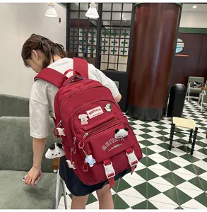 Detailed view of a large capacity red backpack with cute pendants, perfect for student travel.
