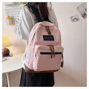 Pink casual backpack detail featuring a suede bottom and front zippered pockets.