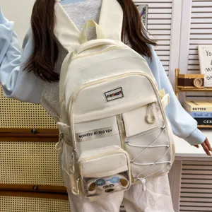 White canvas backpack with multiple pockets, transparent front pouch, and spacious storage.