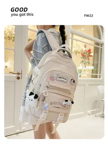 Detailed view of the beige canvas backpack with cute cartoon pendants and multiple compartments.
