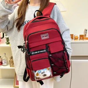 Red canvas backpack detail showing multi-pockets, mesh sides and cute plush front window.