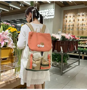 Detail view of the colorful dopamine color-blocking backpack worn by a model in a flower shop.