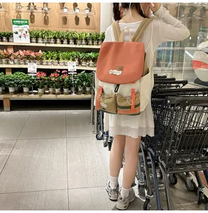 Detail view of colorful canvas backpack worn by model in store, showcasing multi-pocket design.