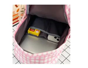 Detail view of the pink checkered backpack interior showing spacious laptop compartment and pockets.