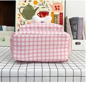 Pink plaid backpack detail view showing bottom fabric and plush bow decoration, casual style.