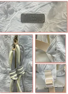 White crinkle nylon backpack detail view, featuring durable straps and custom zipper pulls.