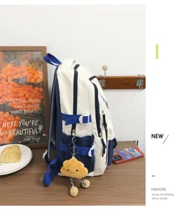 Detailed side view of Japanese color-block student backpack with cute cloud plush pendant.