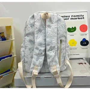 Detailed view of white crumpled backpack with butterfly texture, side zipper pocket and straps.