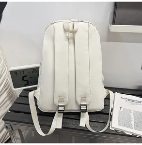 Detail view of the lightweight Japanese style white canvas backpack showing adjustable straps.
