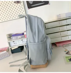 Casual light blue student backpack side view with tan bottom, daily commute school bag.