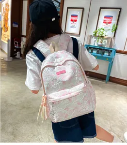 Detail view of the pink textured casual backpack with cute bear pendant and daily wear.