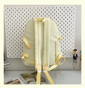 Cute light yellow backpack featuring delicate bow embroidery, side zipper pocket and shoulder straps.