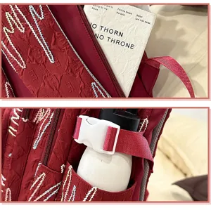 Detailed view of red school backpack pocket and buckle strap, large capacity student bag.