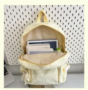 Cute yellow school backpack with lovely embroidery and lace pendant for daily use.