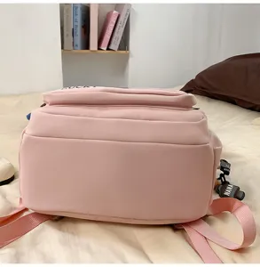 Casual pink school backpack for students, large capacity travel daypack with cute charms.