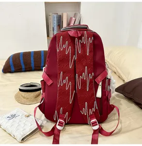 Detail view of the large capacity maroon school backpack with stylish zig-zag straps.