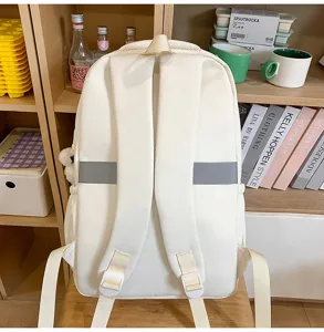 Vista detallada de una mochila escolar blanca lisa minimalista con correas y espalda transpirables.