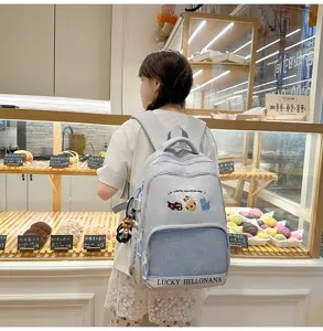 Light blue student backpack with cute cat embroidery, mesh pocket, and large capacity style.
