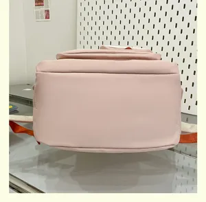 Detalle de mochila escolar minimalista rosa casual, ligera bolsa de viaje diaria.