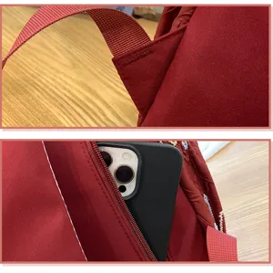 Red minimalist school backpack detail view with durable straps and secure zipper pocket.