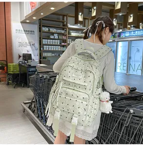 Detailed lifestyle view of the light green casual backpack, featuring cute prints and pockets.