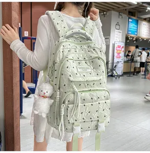 Light green casual backpack with cute plush pendant, multi-compartment student bag detail.