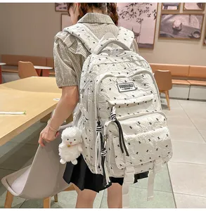 Casual lightweight multi-compartment school backpack with cute plush sheep pendant detail.