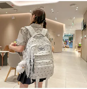 Detail view of the lightweight quilted school backpack with cute pendant in indoor setting.