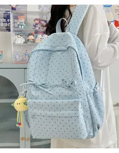 Japanese ins style light blue polka dot backpack with cute bow and plush pendant details.