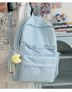 Detailed view of the cute light blue polka dot backpack with bowknot straps and pendant.