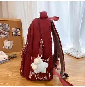 Detailed side view of the burgundy canvas backpack showcasing ample storage capacity and compartments.