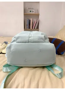 Light blue canvas backpack with cute bow embroidery, perfect for daily student use and casual travel.