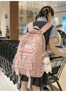 Pink casual school backpack for girls, cute travel daypack with large capacity and pendant.