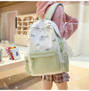Detail view of a cute Japanese style nylon backpack with polka dot bow print and light green pocket.