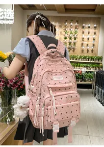 Pink canvas backpack with cute plush pendant, casual school bag for daily travel and students.