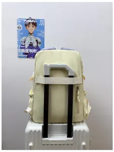 Light yellow casual travel backpack with luggage strap and multiple pockets detail view.