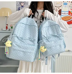 Cute Japanese style polka dot backpack for women, casual student school bag with bow and charm.