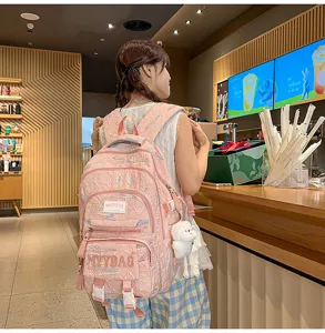 Pink student backpack with large capacity and cute pendant for teenage girls daily school use.