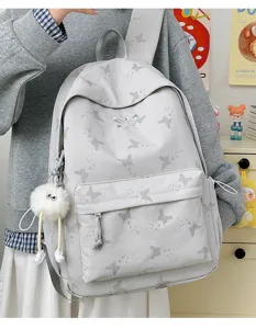 Detailed view of the grey butterfly print backpack, casual school bag with plush pendant.