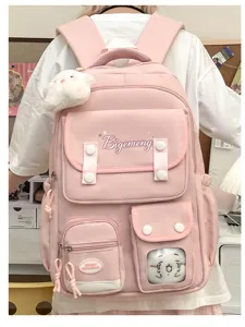 Detailed view of the pink college style backpack with multiple compartments and cute plush pendant.