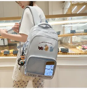 Detail view of the light blue cute student backpack featuring charming cat embroidery and pocket.