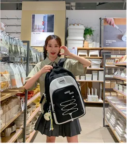 Detailed view of large capacity black and white color block student backpack in store setting.