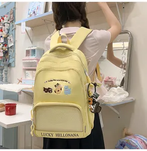 Details of the cute yellow student backpack with animal embroidery and front mesh pocket.
