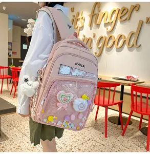 Mochila rosa de estilo japonés con bolsillo frontal transparente y colgantes de felpa para estudiantes.
