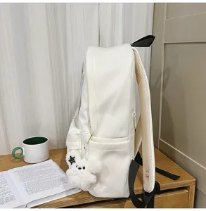 Minimalist white student backpack, large capacity campus school bag with cute bear pendant detail.