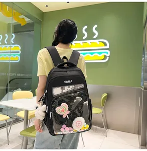 Mochila ita negra de estilo japonés con bolsillo frontal transparente y bonitos colgantes.